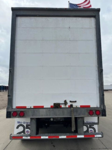Rear view of a 2014 Wabash van trailer showing blank white back door, small taillights, and bumper with reflective tape.