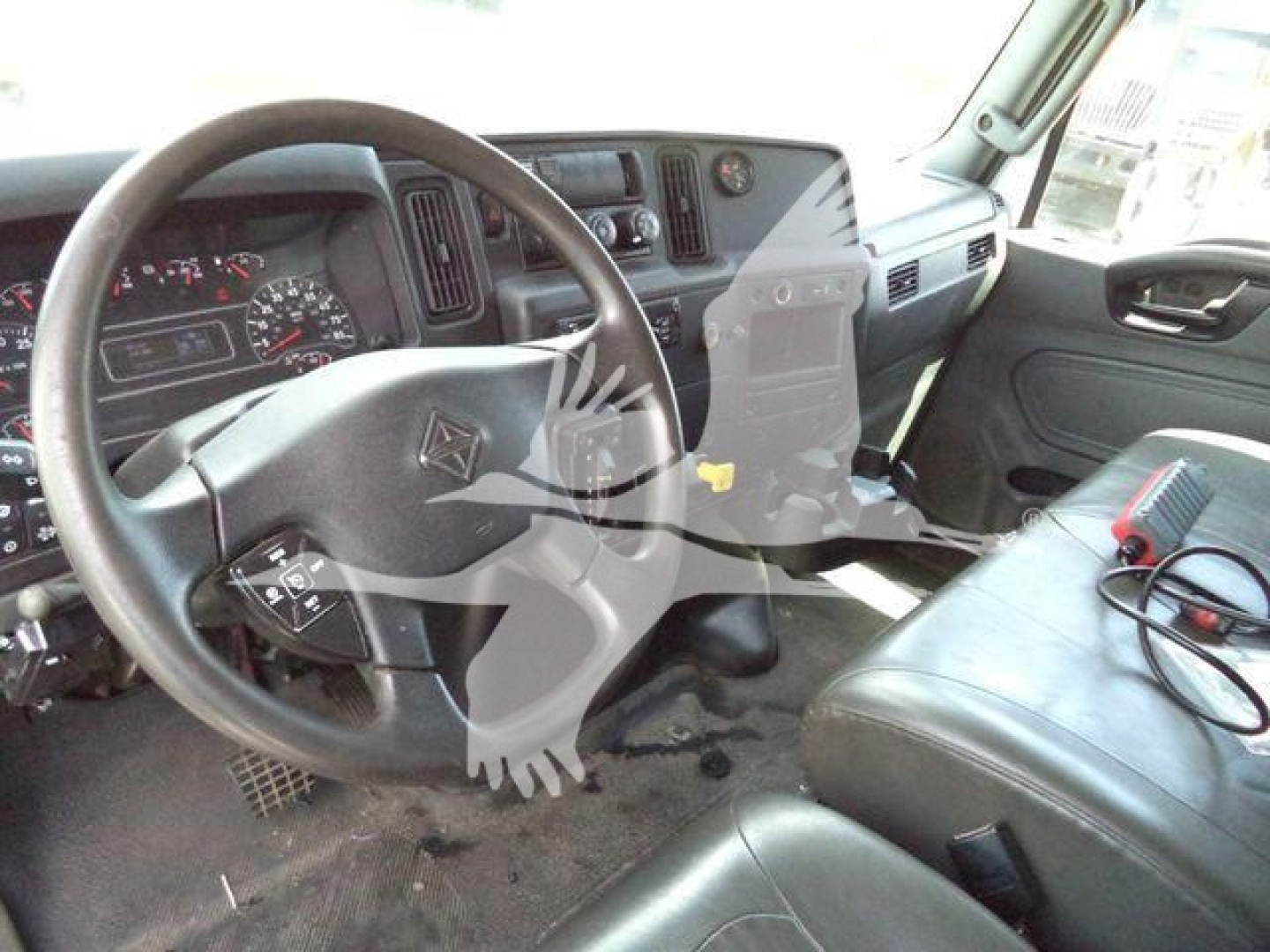 Interior cab view of a 2019 International 4300 rolloff truck showing steering wheel, dashboard, and front bench seat.