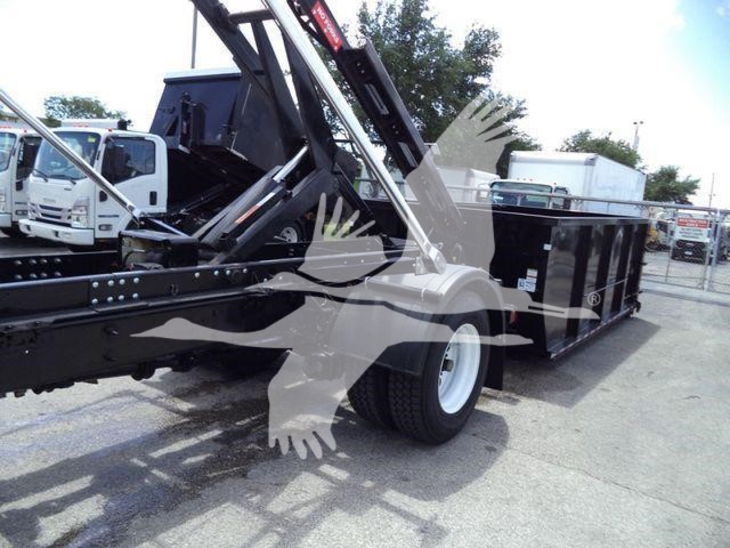 2019 International 4300 roll-off truck in-service with hydraulic crane/boom and empty bed, side view showing wheel, chassis, and rear hydraulic apparatus.