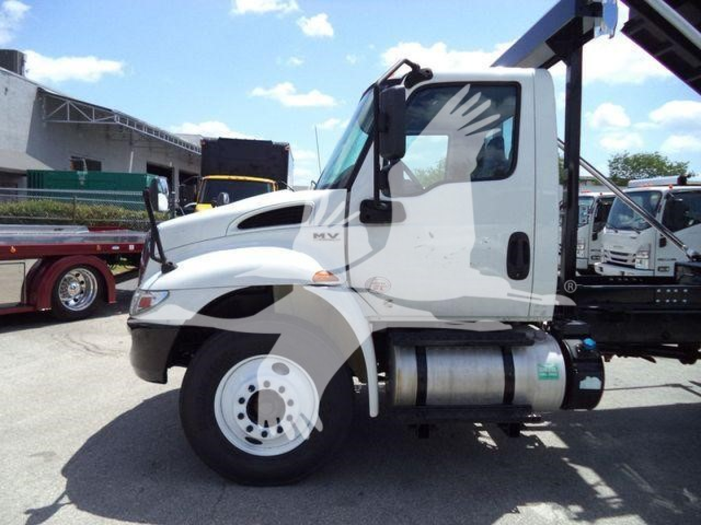 2019 International 4300 rolloff truck side view showing cab, fuel tank, and wheel.