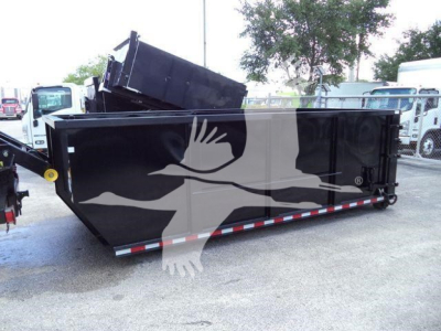 Side view of a black roll-off truck box with a raised hopper and white graphic design.