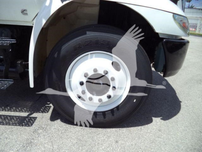 Wheel and front fender of a rollout truck showing tire with rim and partial front bumper. Visible text on tire reads 'R-22-19' and wheel lug pattern.