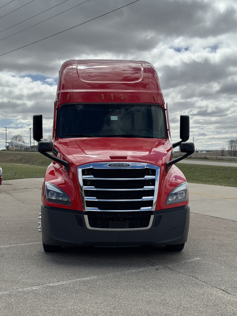 Front view of a red 2022 Freightliner Cascadia 126 conventional sleeper truck with large grille, black bumper, and mirrors.