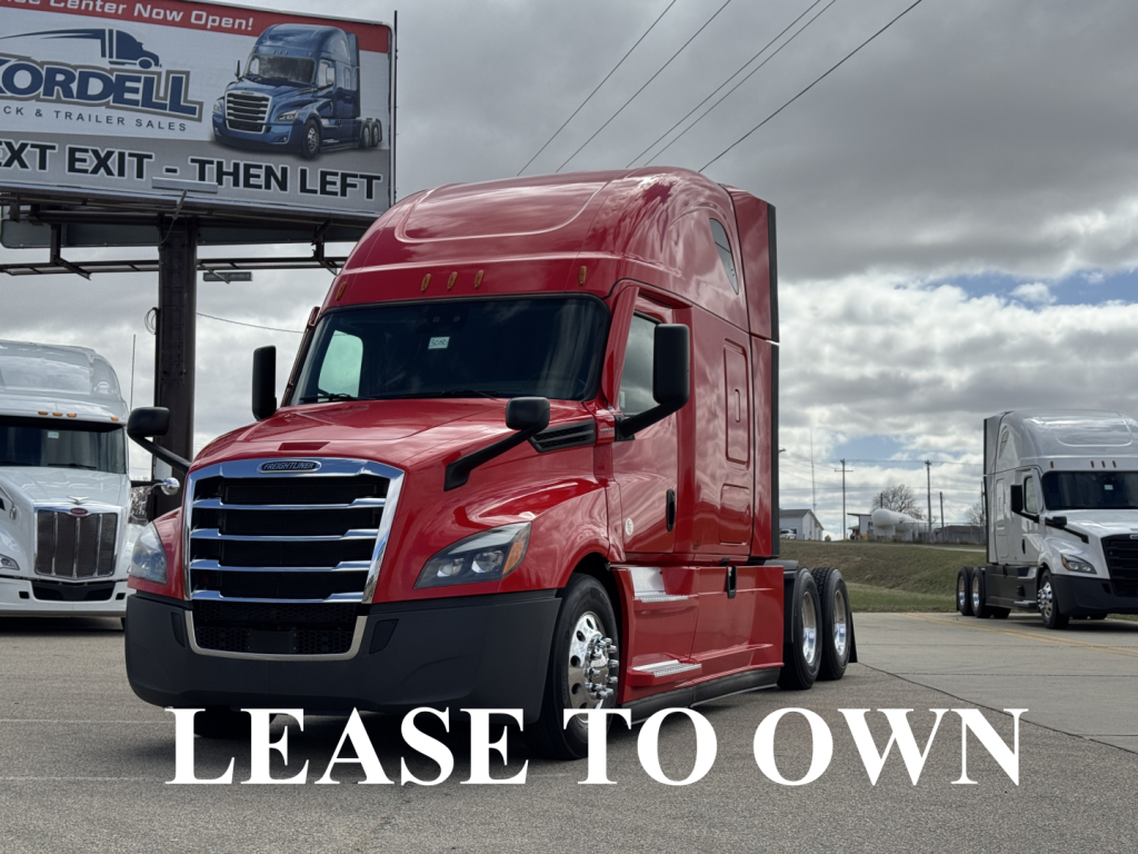 Freightliner Cascadia 126 semi-truck in red, parked in lot with others; large white text 'LEASE TO OWN' across the image. Billboard in background.