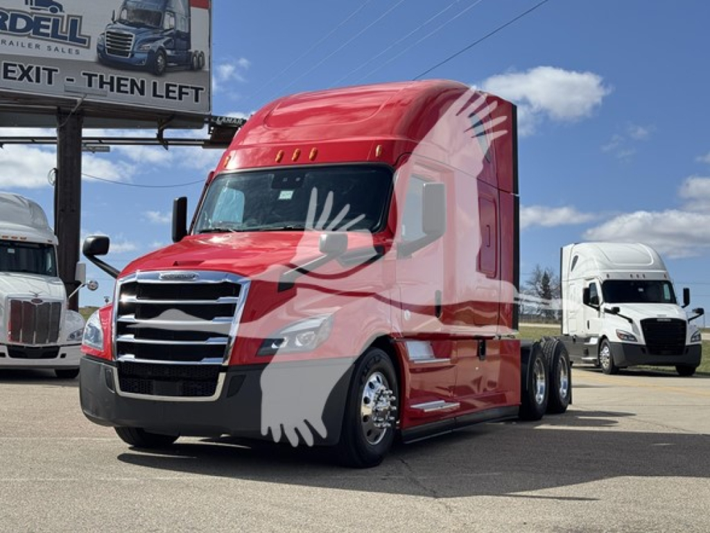 2022 Freightliner Cascadia 126 truck in red with sleeper cab, parked at a dealership lot. Visible signboard reads 'EXIT - THEN LEFT' and there are other trucks in the background.