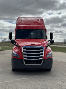 Front view of a red 2022 Freightliner Cascadia 126 conventional sleeper truck with large grille, black bumper, and mirrors.