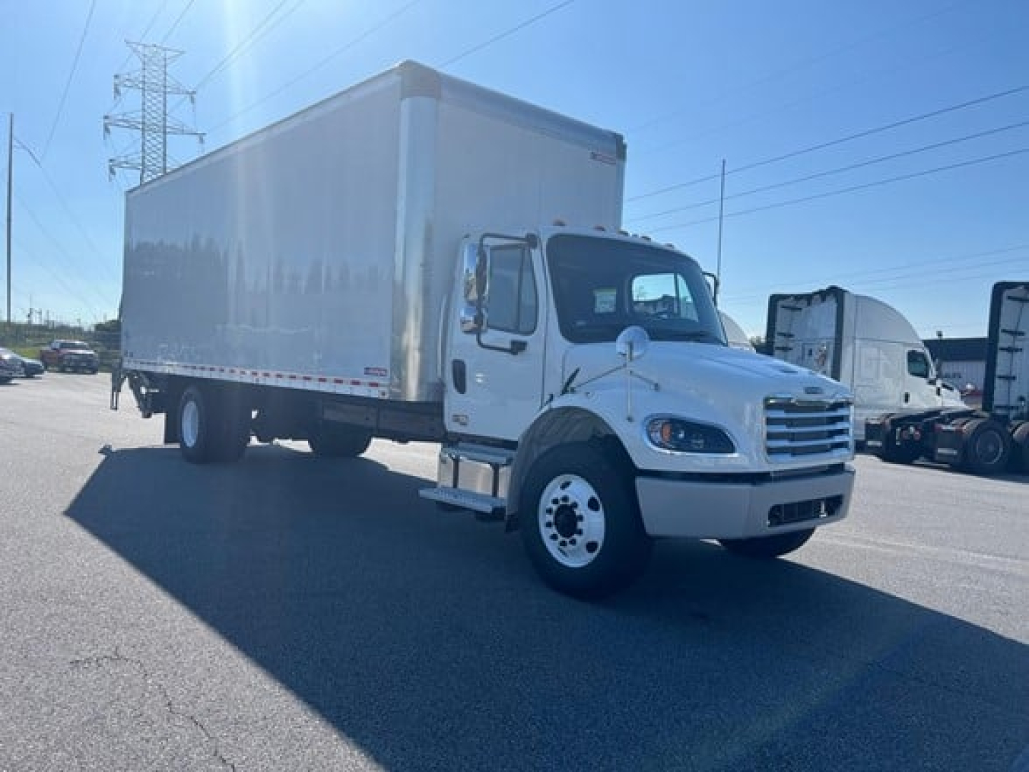 Truck: 2027 Freightliner M2 106 Plus box truck with cargo box, side view showing cab and box body, VIN 1FVACWFC1VHWY3825.