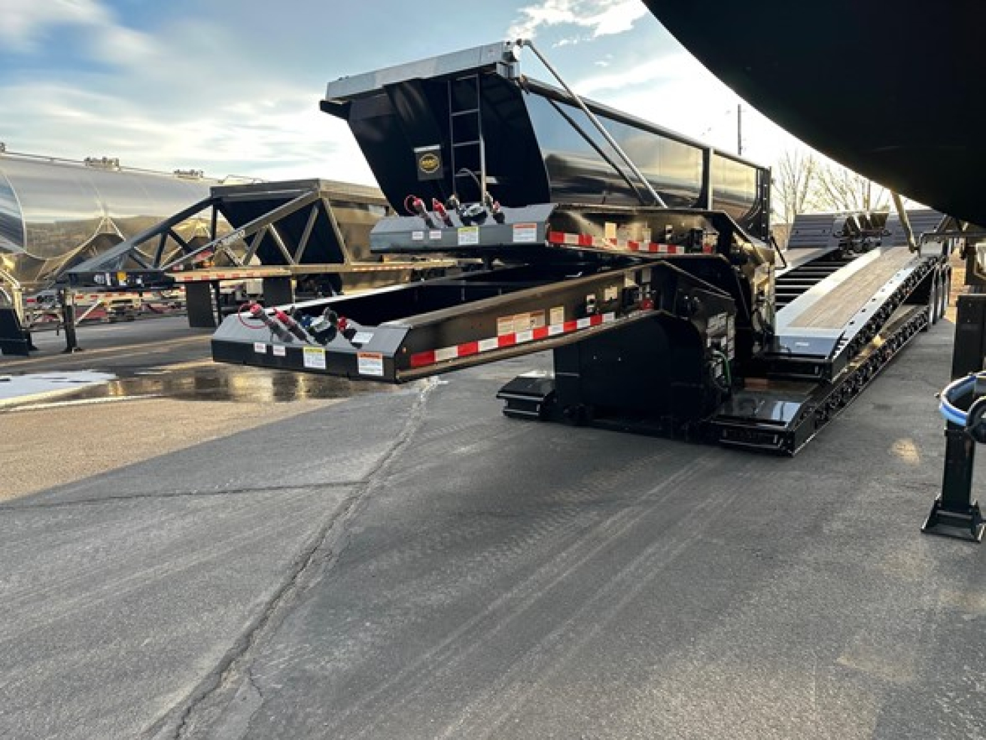 Load King Ss lowboy trailer view showing ramp and loading platform with reflective tape and hydraulic components.