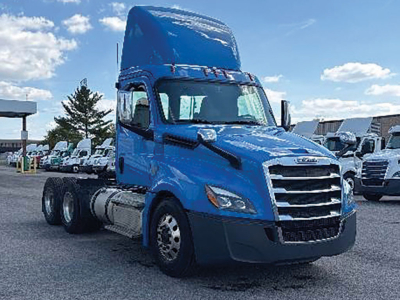 Blue Freightliner Cascadia 116 tractor cab, front-right view, with dual rear axles and long hood, 2022 model year, stock number 558600.