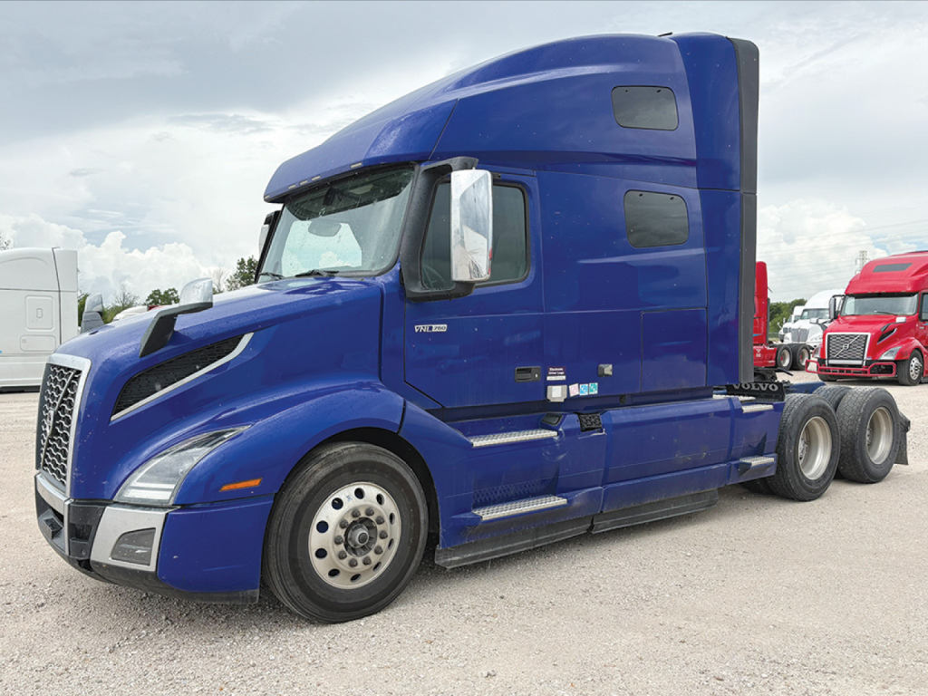 Blue Volvo VNL 760 sleeper cab tractor in side view with twin rear wheels and aerodynamic hood.