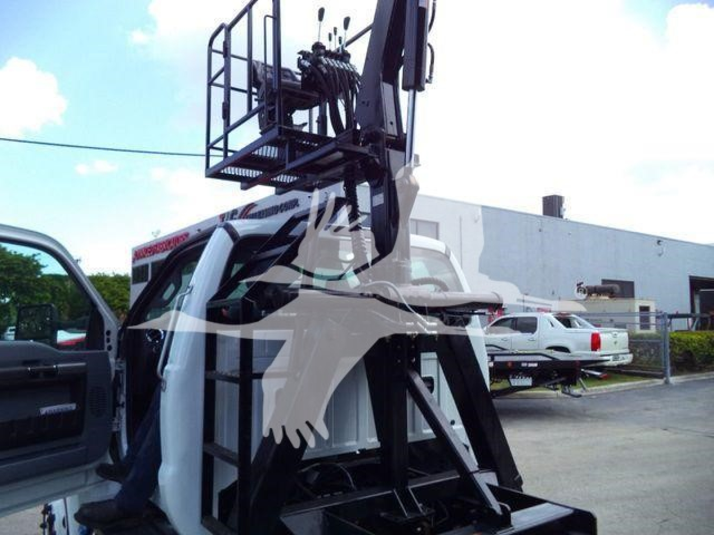 Ford F-650 grapple truck with mounted hydraulic crane, cab-side view showing operator door and grapple boom structure.