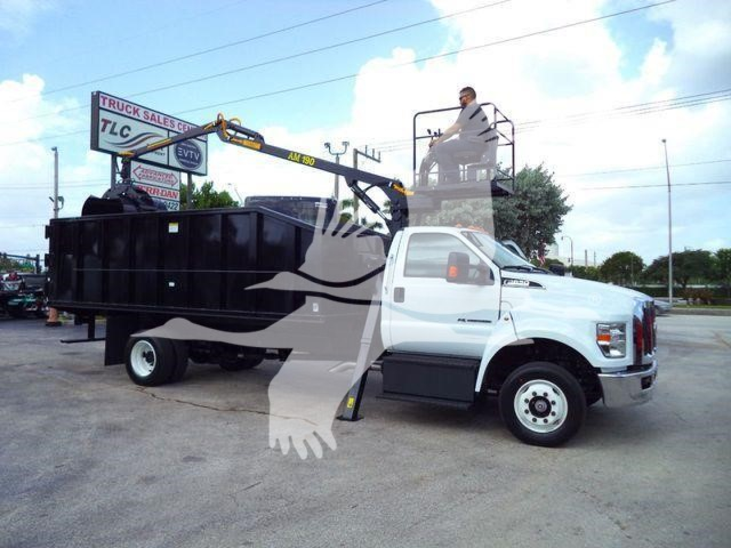 Ford F650 grapple truck with platform and crane in-service showing grapple arm and truck cab, no visible text legible