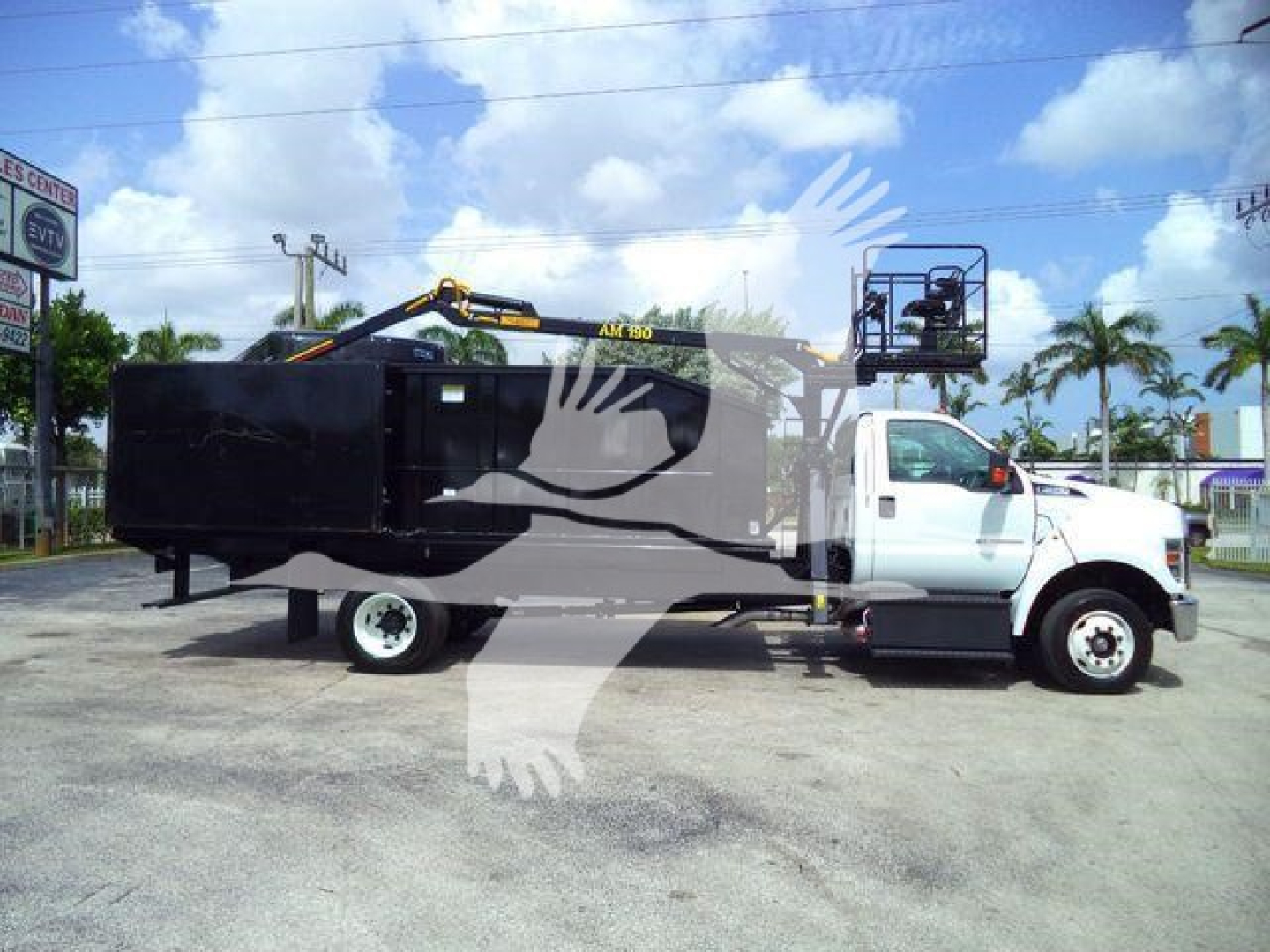 Truck with grapple crane on a white Ford F650 cab showing a black body and equipment, stock number 21YARDGRAPPLE, open area background