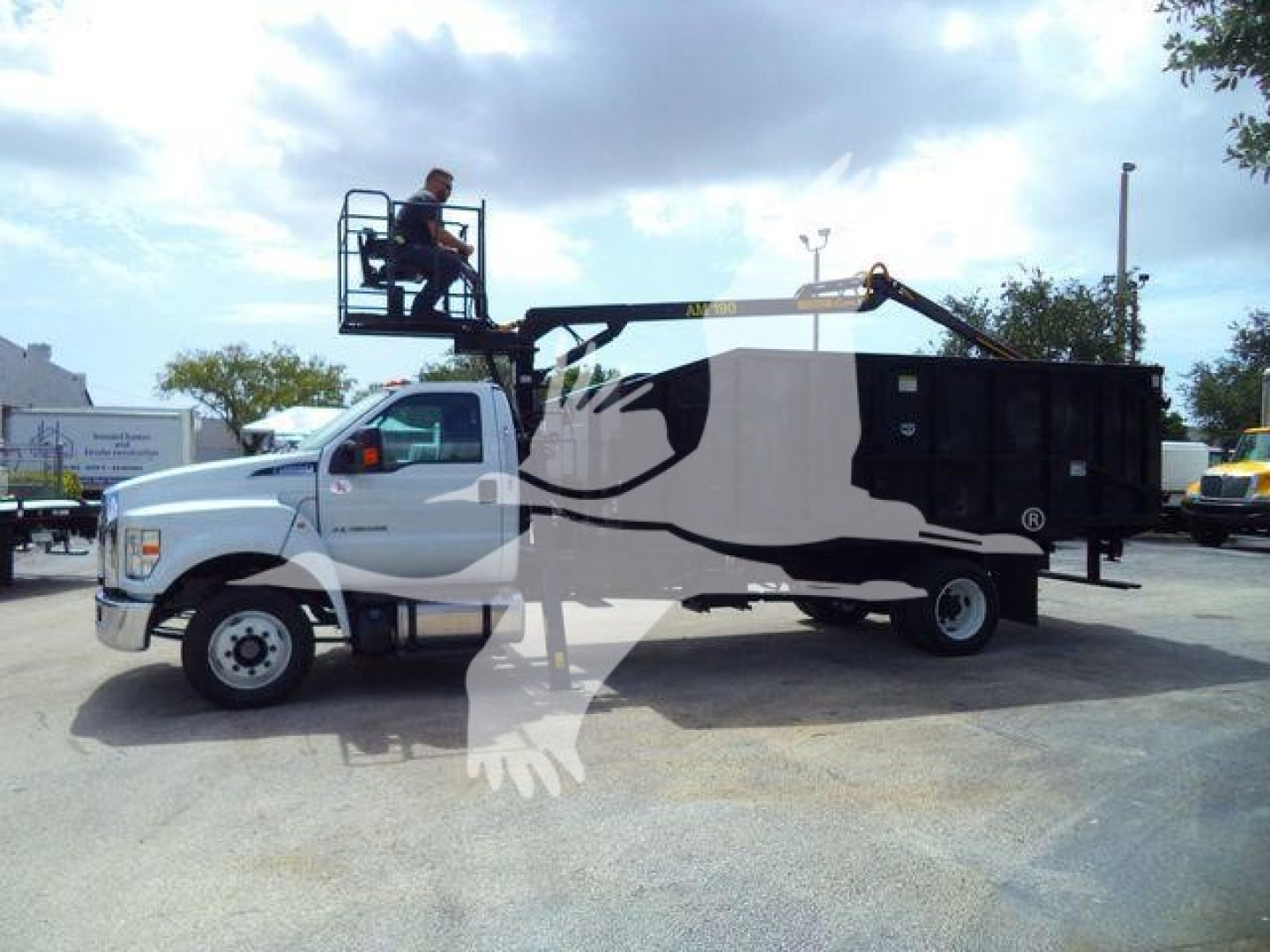 Ford F-650 GVW grapple truck with a raised hydraulic platform and grapple arm on a flatbed body, white cab, graphic wrap, stock number 21YARDGRAPPLE.