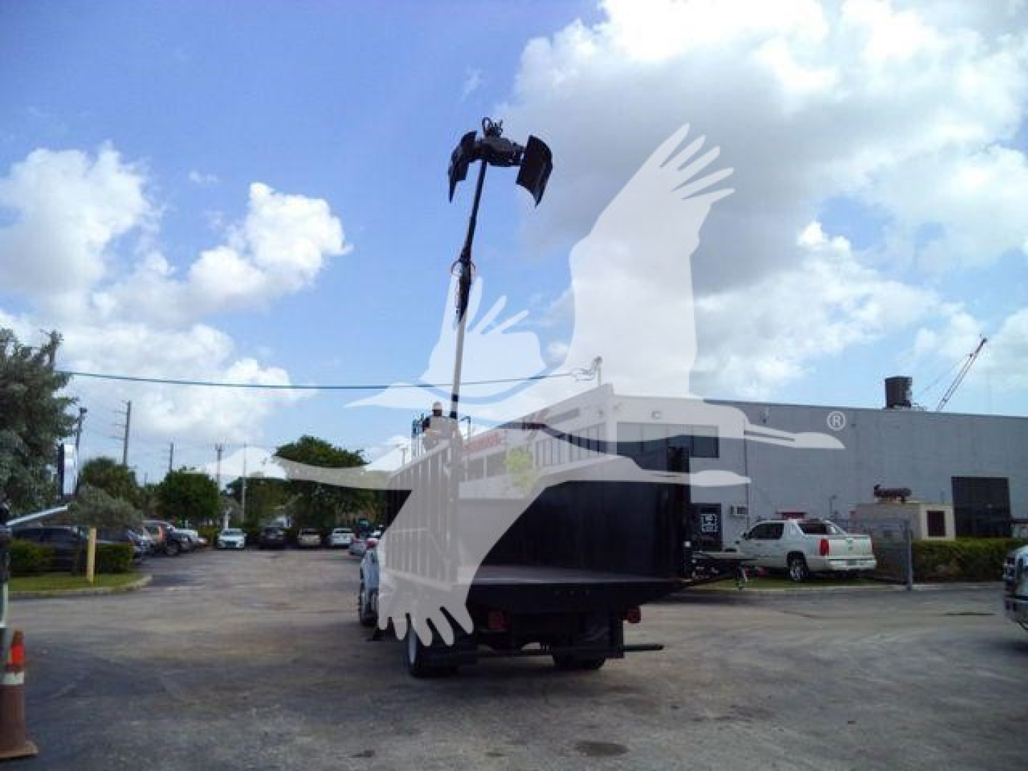 2023 Ford F650 SD Grapple truck with crane arm visible in rear, dealership lot in background.