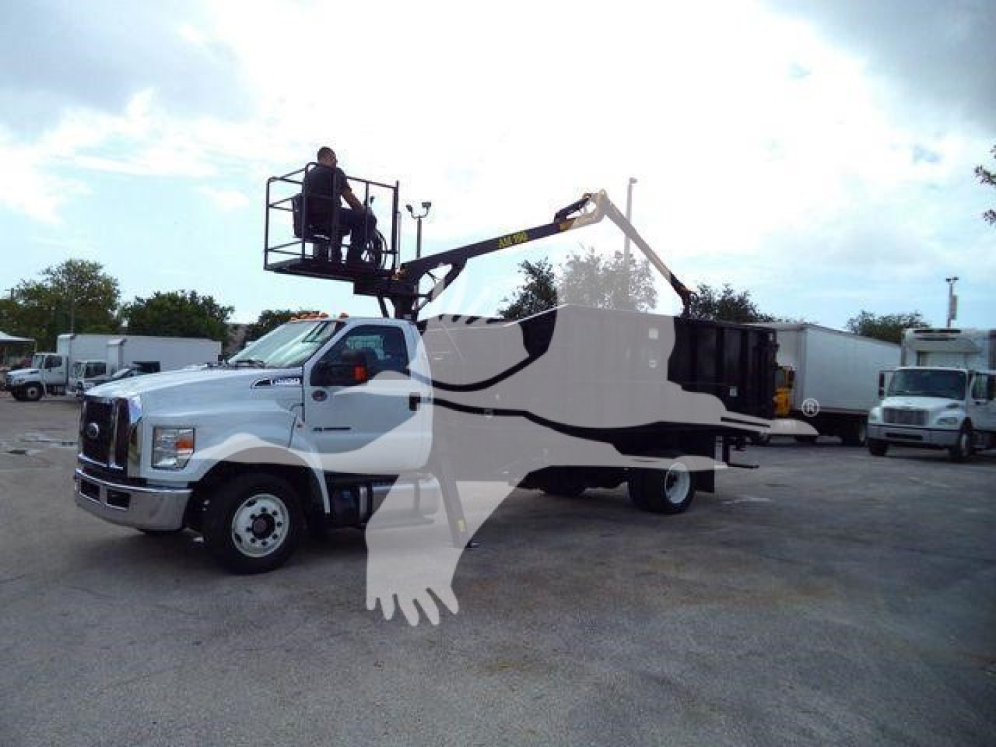 Truck with a mounted grapple crane on a white and black equipment body. No visible text legible on the vehicle or background.
