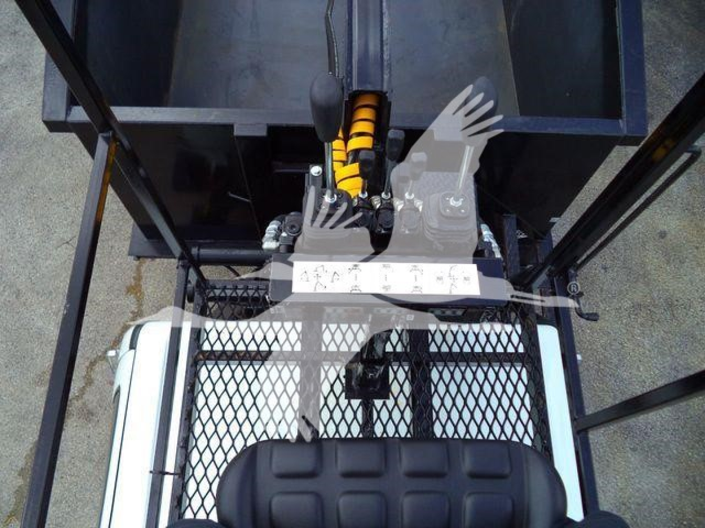 Truck bed view showing grapple attachment and operator seat from overhead; metal mesh platform, hydraulic arm, and control levers visible.