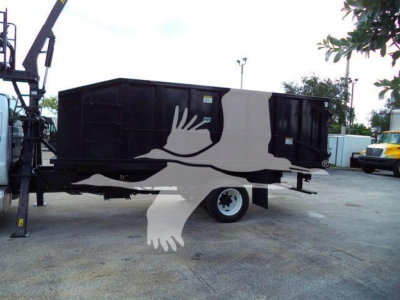 Truck trailer with grapple attachment and painted graphic of a white hand reaching from a black and tan container.