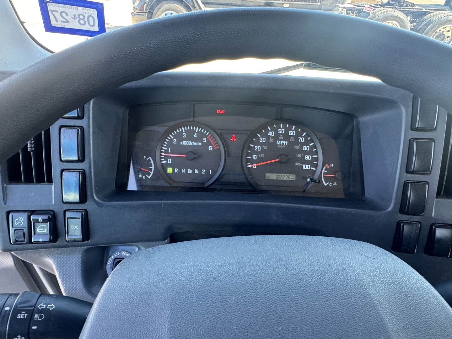 Isuzu NPR-HD dashboard view showing gauges and steering wheel with odometer and speedometer, in-service condition for 2021 heavy truck.