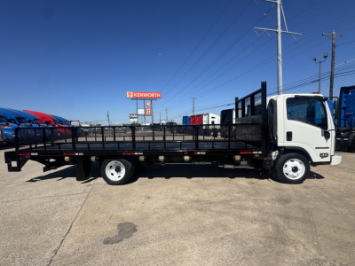 Isuzu NPR-HD flatbed truck in side view showing flatbed and cab with white exterior.
