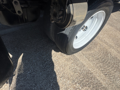 Isuzu NPR-HD truck wheel and front suspension view showing tire and rim.