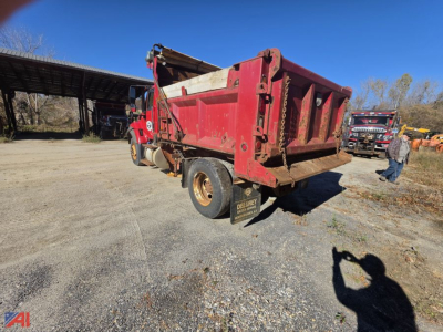 Dump truck bed of a red 2015 International WorkStar 7400 with plow, side view showing rear chassis and mudflap.
