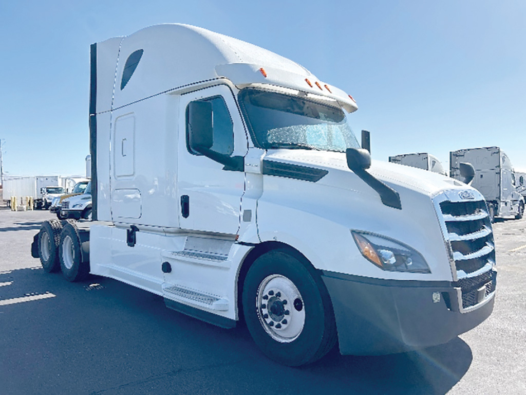 Truck cab side and front view of a white Freightliner Cascadia126 sleeper tractor in a lot.