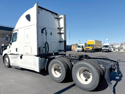 Freightliner Cascadia126 sleeper tractor showing rear dual wheels and fifth wheel hitch with white cab.