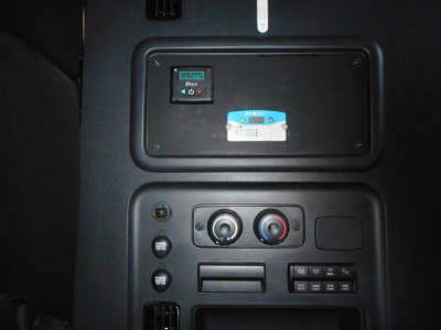 Truck dash panel with climate controls and USB/12V accessories; upper panel shows display, blue label, and white sticker.