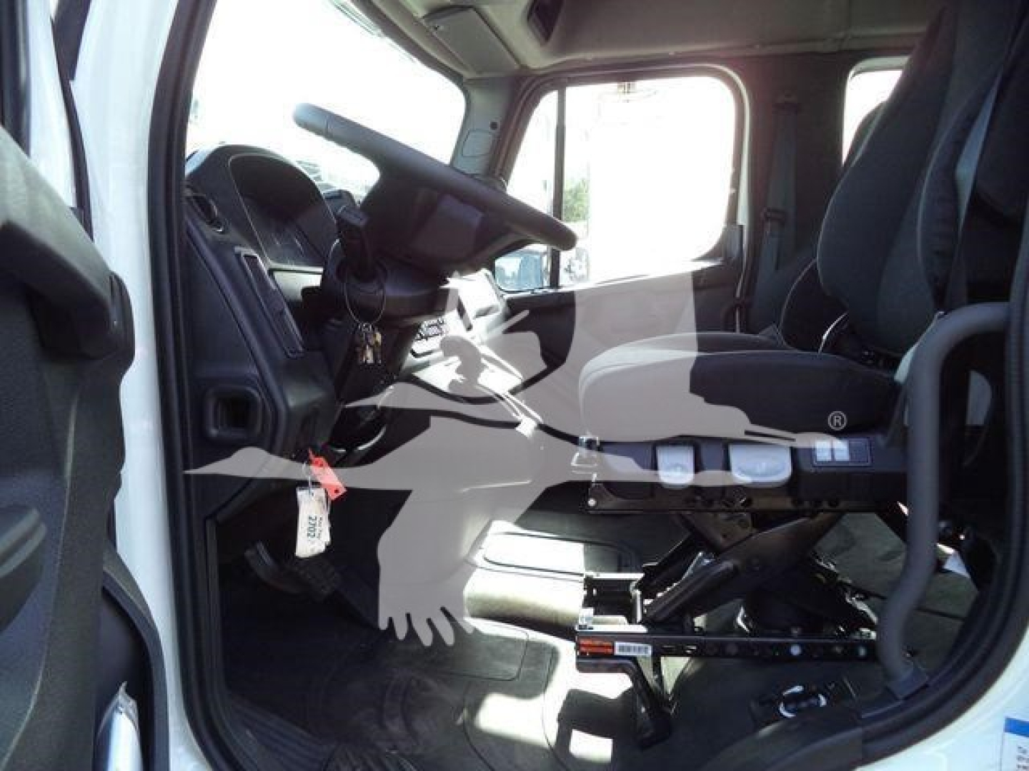 Freightliner Business Class M2 106 truck cab interior showing cabin and driver's seat with steering wheel and controls.