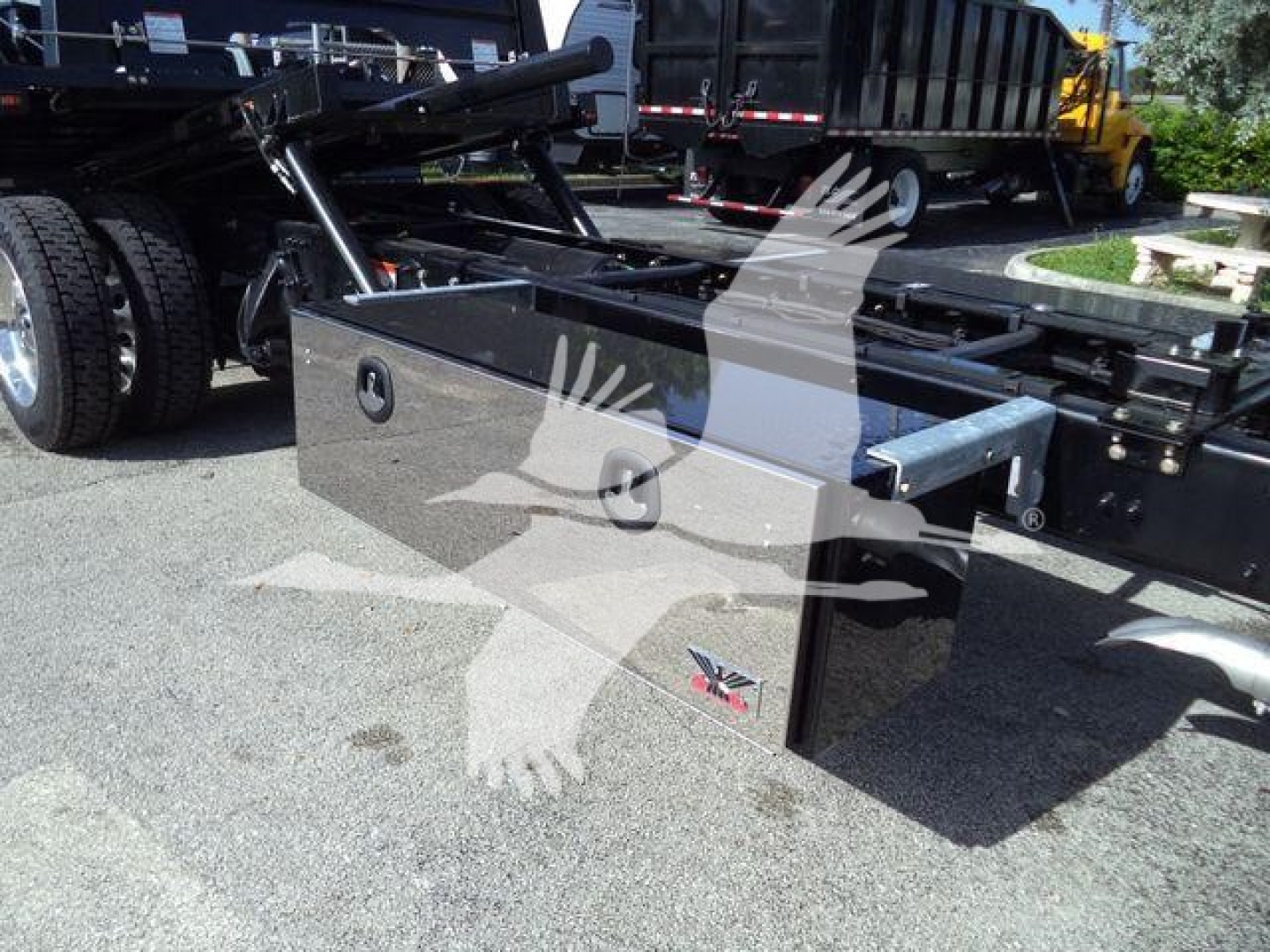 Truck bed toolbox mounted on Freightliner Business Class M2 106 rollback chassis with side storage box and hydraulic lines visible.