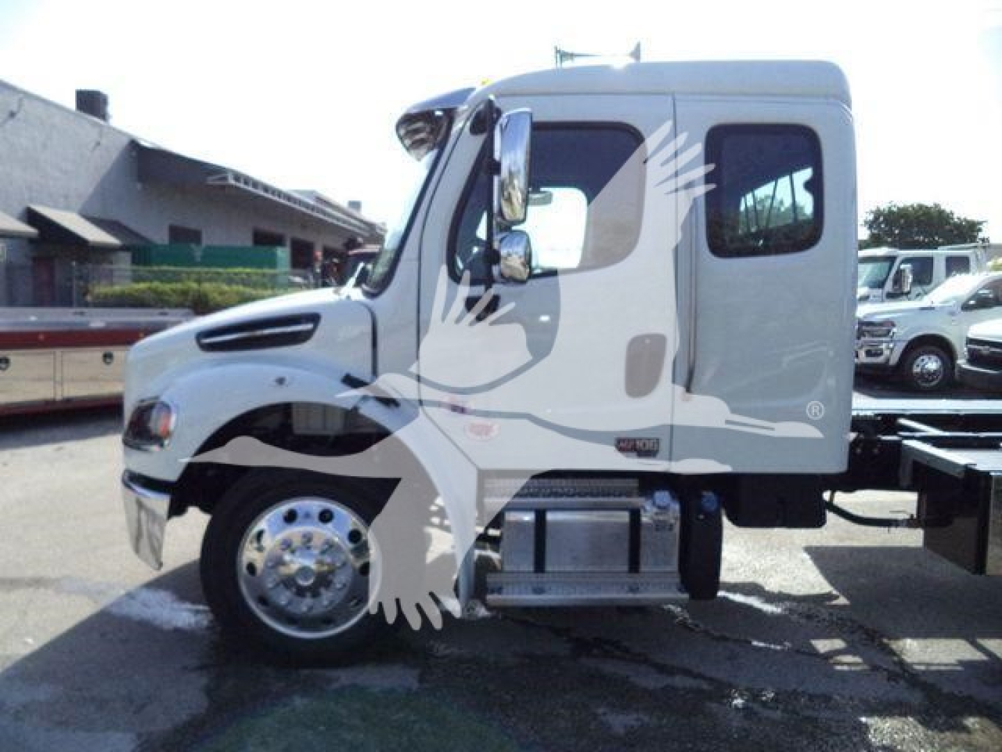 Freightliner Business Class M2 106 truck side view showing cab with chrome mirrors and steps.