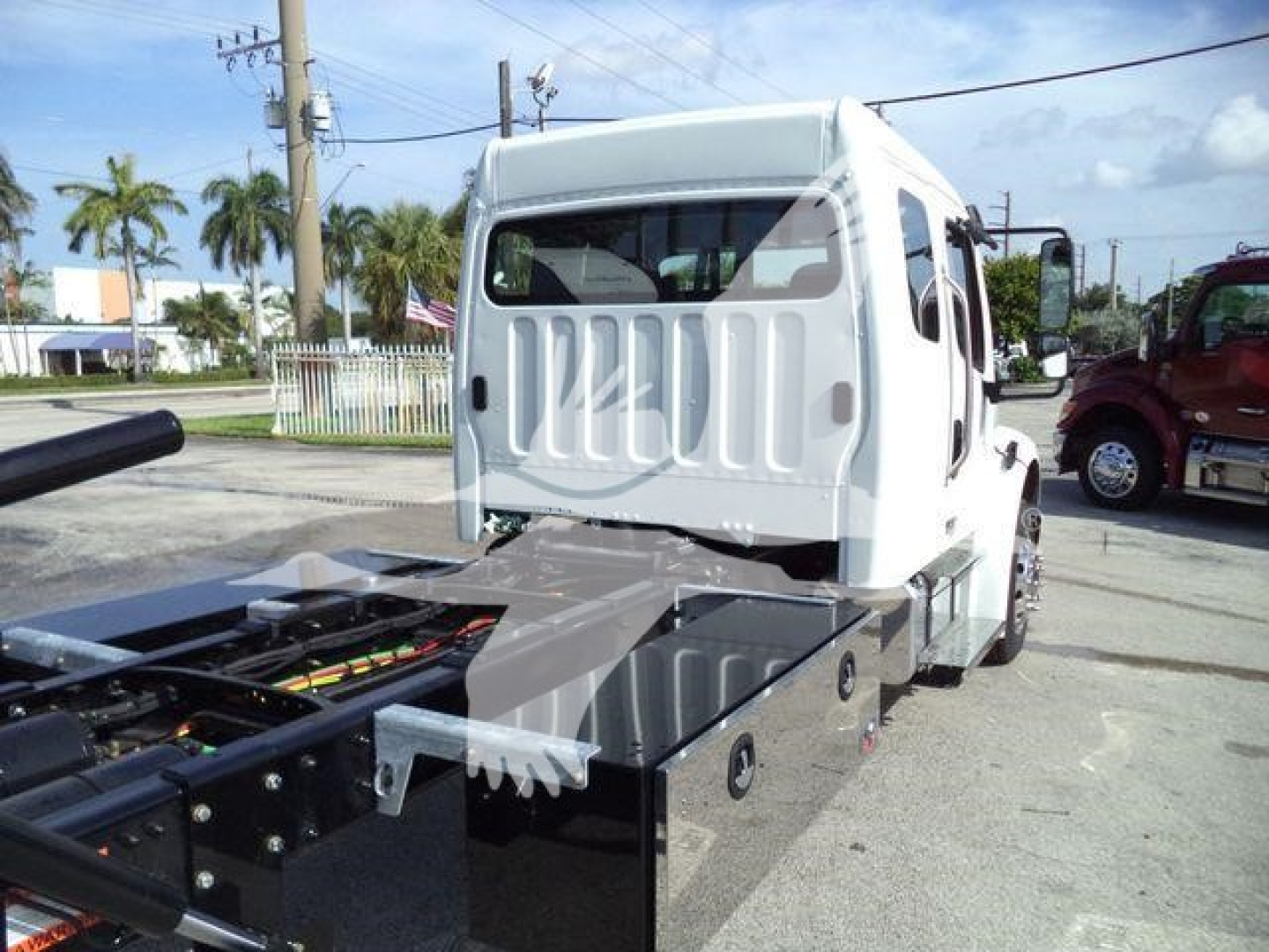 Truck cab and chassis view showing Freightliner Business Class M2 106 with flatbed chassis and side boxes.