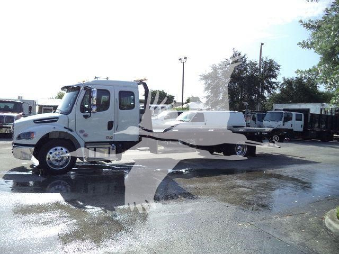 Truck cab and rollback chassis of a 2027 Freightliner Business Class M2 106 showing front profile, cab doors, and long flatbed.