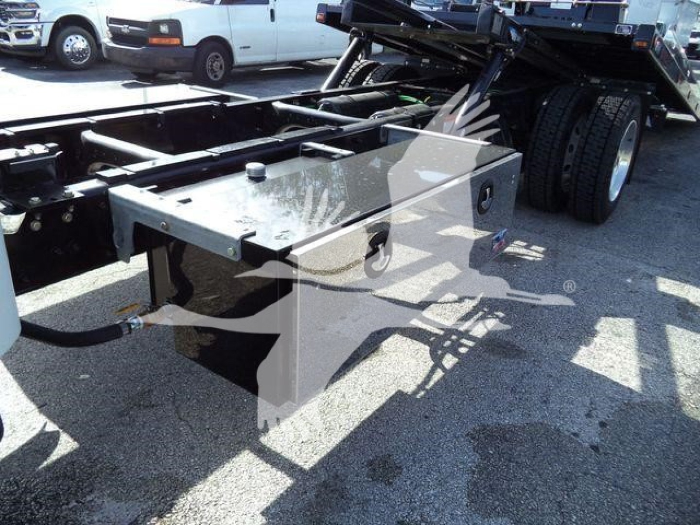 Freightliner M2 chassis toolbox and rollback bed area showing mounted metal toolbox and hydraulic lines.