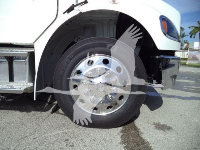Freightliner Business Class M2 106 front wheel well and tire showing chrome hub with lug nuts.