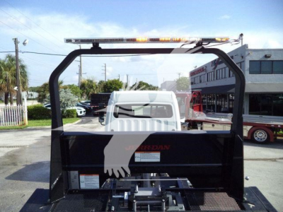 Truck bed equipment showing a Freightliner Business Class M2 106 rollback setup with a black metal frame, rear-view in a dealership lot.