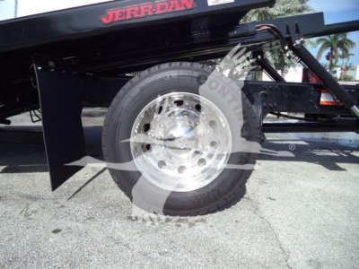 Truck chassis side showing wheel and hydraulic rollback components.