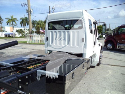 Truck cab and chassis view showing Freightliner Business Class M2 106 with flatbed chassis and side boxes.