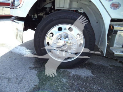 Wheel and front fender of a Freightliner M2 106 rollback truck showing a Continental tire and chrome hub with lug nuts.