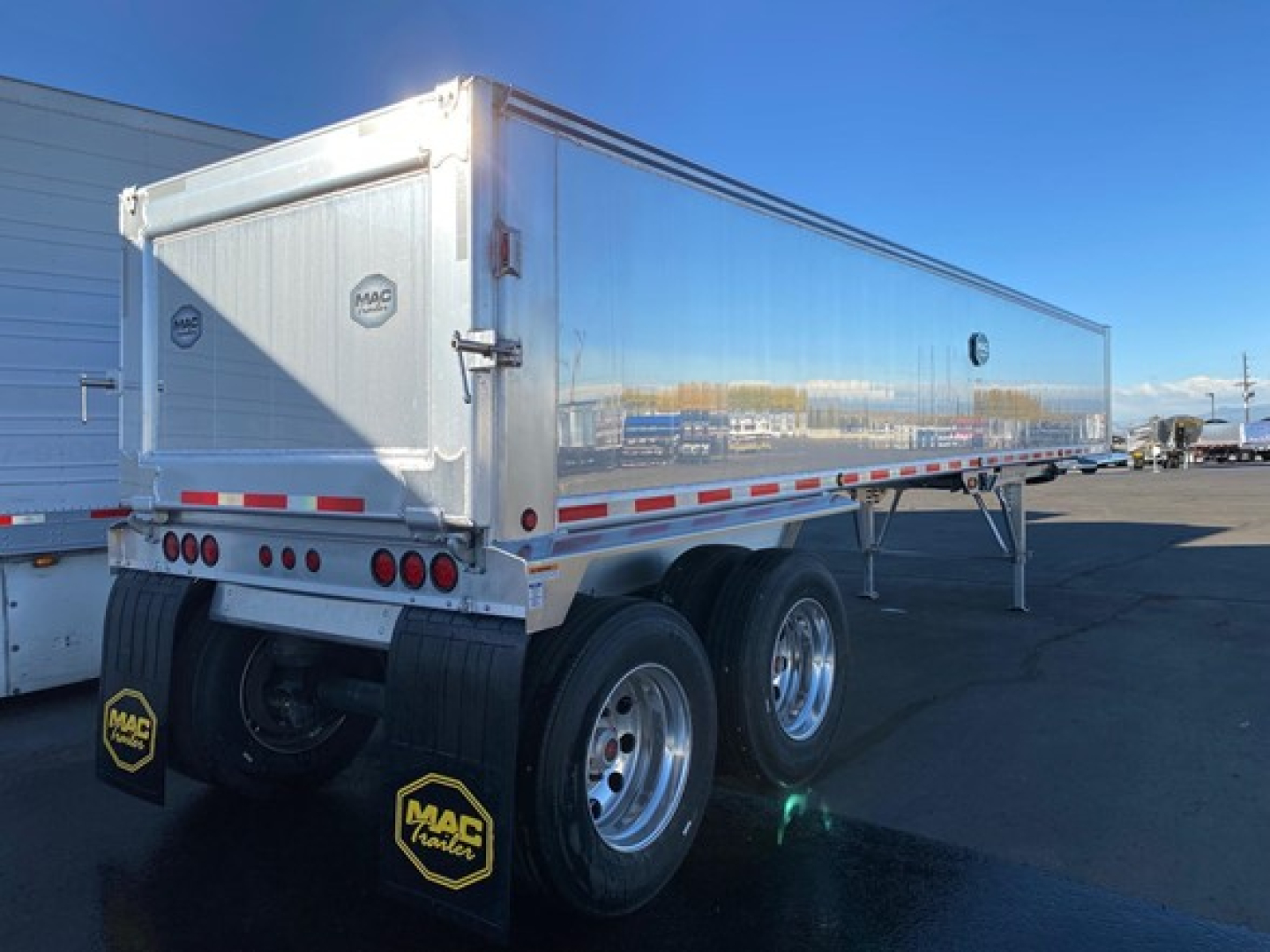 Mac Western Lightweight trailer with dual rear axles and reflective red-white tape, aluminum body, MAC mud flaps.