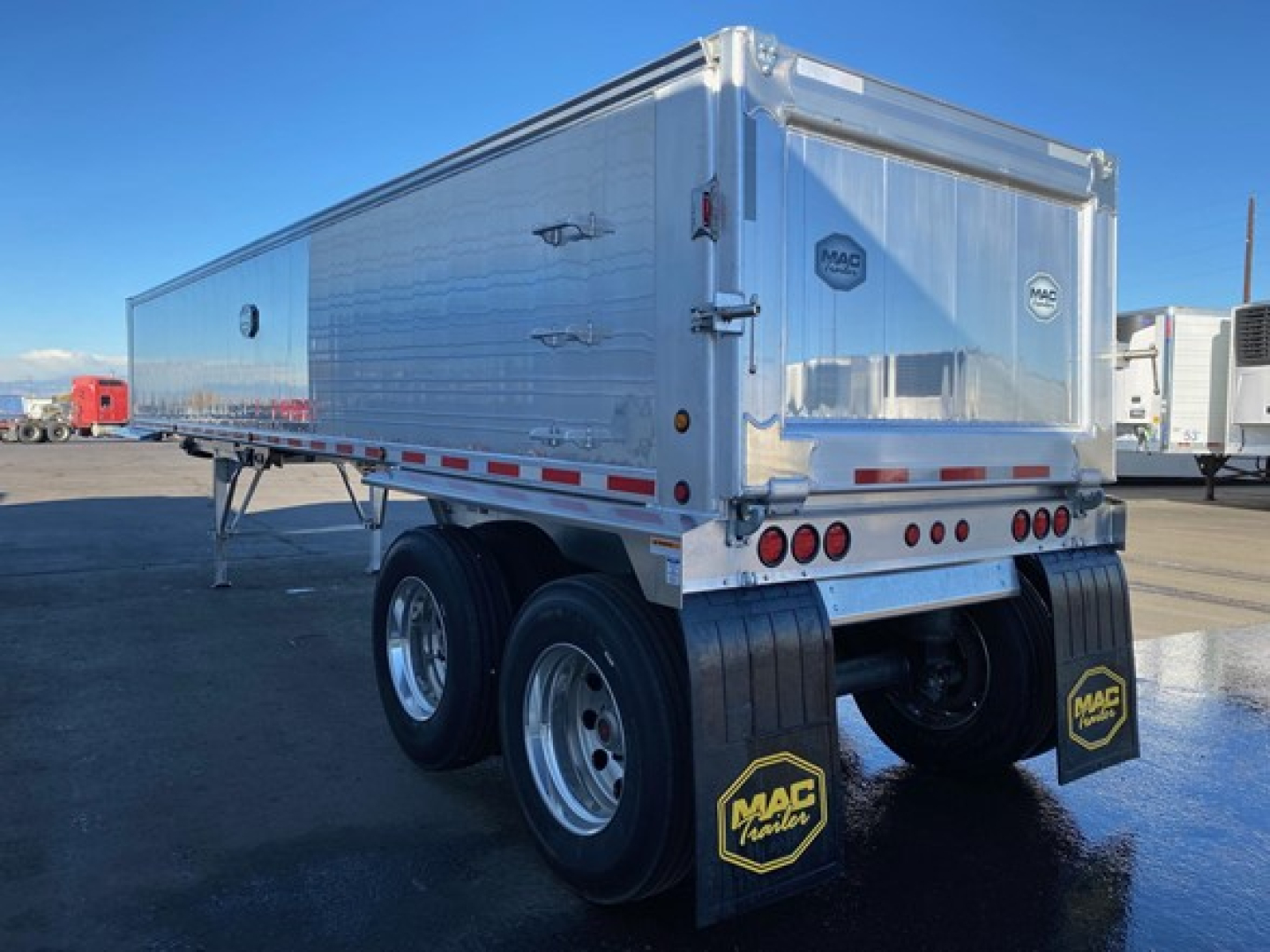 Mac Western Lightweight trailer side and rear view showing dual rear axles, MAC mud flaps, silver aluminum finish, rear doors, and reflectors.