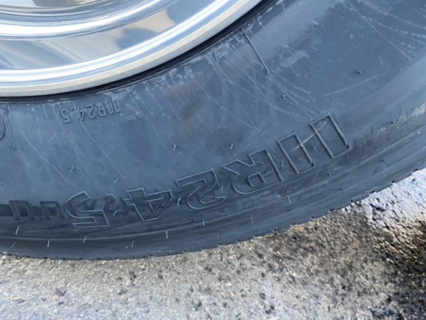 Tire sidewall with visible text 'Tubr-5' and numbers on a trailer wheel. Part of wheel rim is visible.