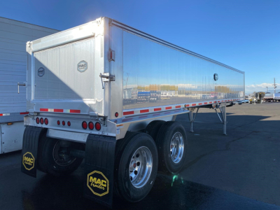 Mac Mac Western Lightweight dump trailer rear and side view showing dual rear axles, chrome wheels, aluminum body, tailgate with MAC logo, mud flaps, and reflective safety stripes.