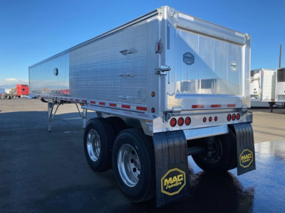 Mac Western lightweight dump trailer rear and side view showing tandem axle with mud flaps and MAC branding, aluminum walls, rear doors, and taillights.