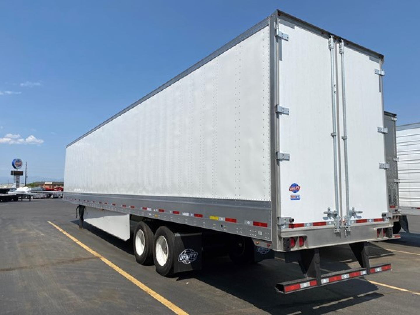 Utility 4000Dx trailer showing side and rear with triple axle configuration and rear doors.