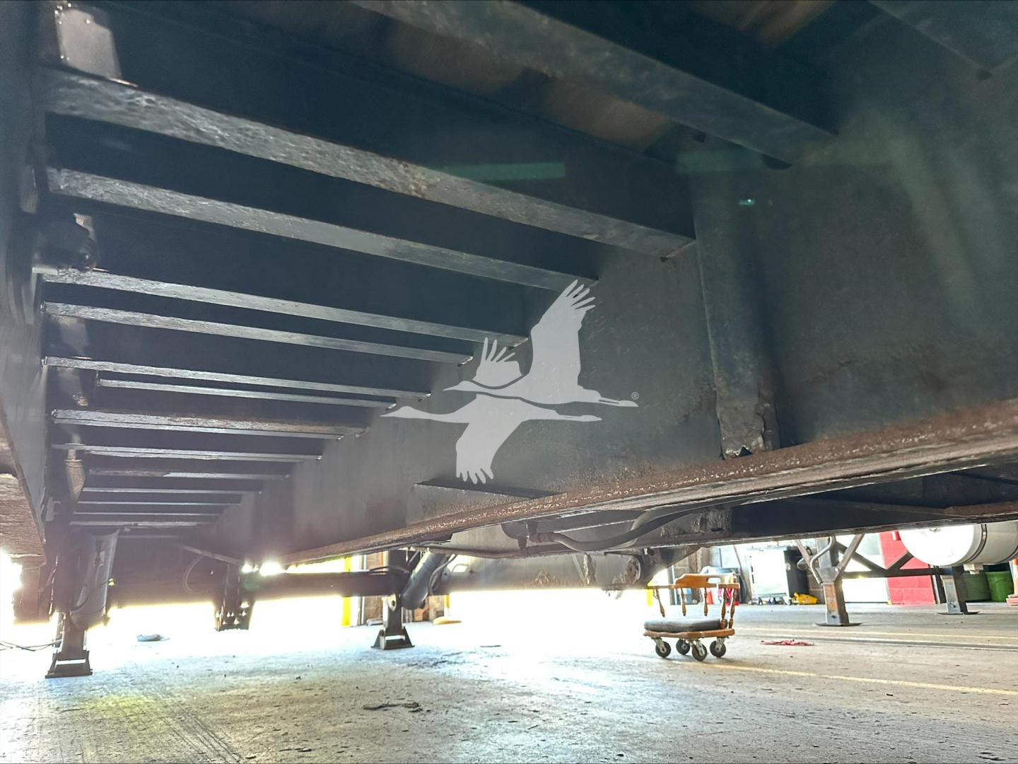 Underbelly view of a 2014 Landoll 440B trailer showing structural frame and a white bird silhouette logo on the side.
