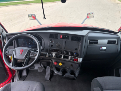 Kenworth T680 interior dash with steering wheel, instrument cluster, center console, and pedals visible.