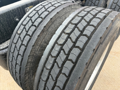 Kenworth truck wheel tires close-up showing tread pattern and dual rear axle area.