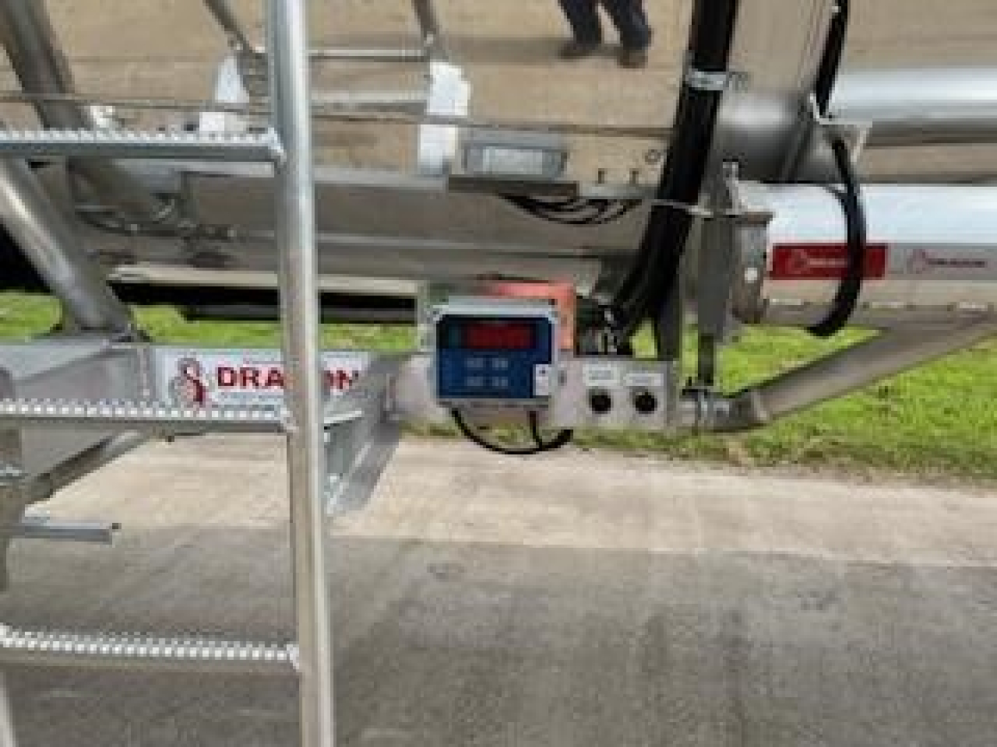 Trailer control panel and tubing on a Dragon 8400 trailer showing digital readout and hydraulic controls.